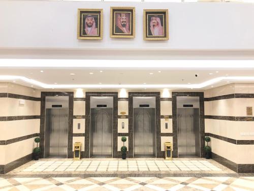 麦地那Zaha Al Madina Hotel的墙上挂着照片的建筑物里一排电梯
