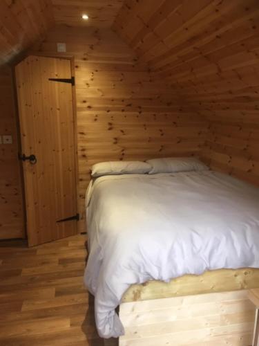约维尔Lodge的卧室配有木墙内的一张床