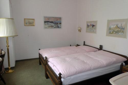 布鲁嫩Villa Deck的一间卧室配有带粉色床单和台灯的床