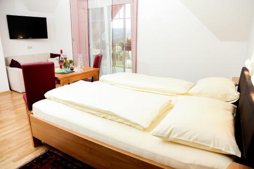 洛伊查赫Weingut Zirngast的一间卧室配有一张床、一张桌子和一个窗户。