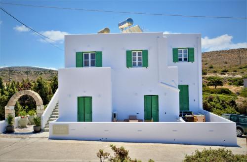 PachainaDioni lux inn的山上的白色房子,设有绿门