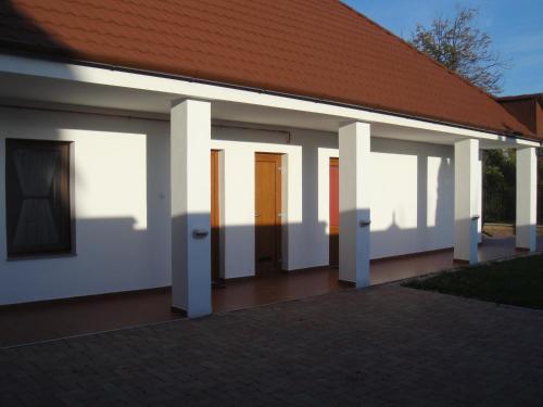 保克什Paks Panzió的白色墙壁和红色屋顶的建筑