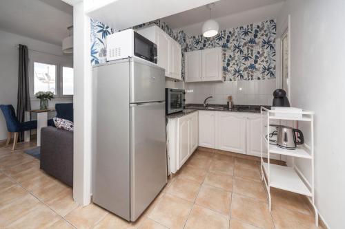 宏达海滩Luxury Suite Sea Front的厨房配有白色橱柜和冰箱。