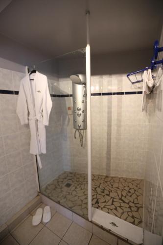 哥西尔克里奥尔酒店的配有白色浴袍和淋浴的浴室