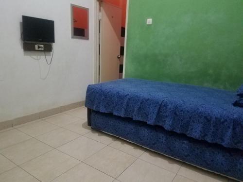 LampungCendrawasih Syariah Homestay的一间卧室配有蓝色的床和电视