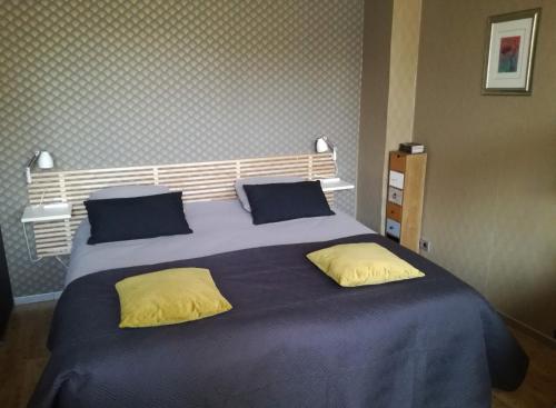 吕伐登B&B de Ferver的一张大床,配有蓝色床单和黄色枕头