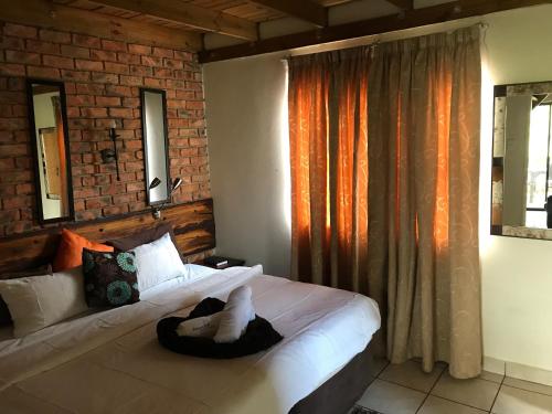 布隆方丹Weltevreden Game Lodge的一间卧室设有一张床和砖墙