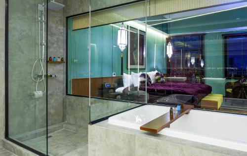 万象Lao Poet Hotel的带浴缸和玻璃淋浴间的浴室。