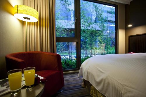 台中市星享道酒店 的酒店的客房 - 带一张床、椅子和窗户