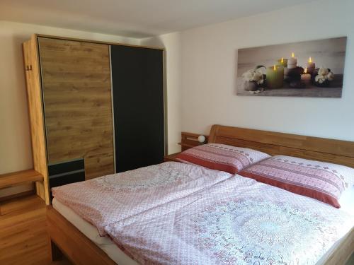 上特劳恩Haus 66的一间卧室配有一张床和一个木制橱柜