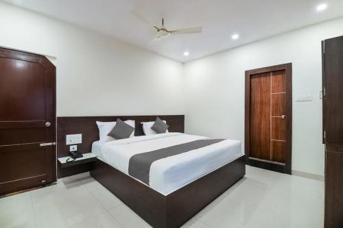 维沙卡帕特南Sri Raghavendra Inn的一间卧室设有一张大床和一扇木门