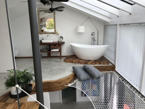 RottauDas Poolhaus的浴室配有白色浴缸和水槽