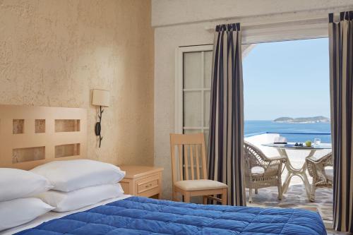 加夫里翁安德罗斯假期酒店的一间卧室配有一张床,享有海景