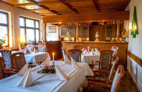 奥古斯都堡奥古斯塔酒店的餐厅配有桌椅和白色的桌布