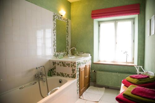Yvoir莱夫德雷恩布住宿加早餐旅馆的带浴缸、水槽和窗户的浴室
