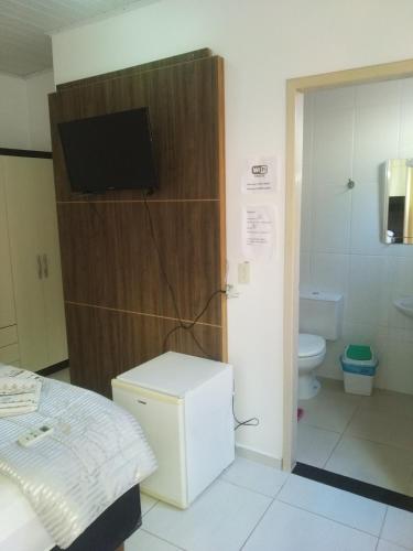 伊瓜苏pousadavaledasaguas的客房设有一张床和一间带电视的浴室。