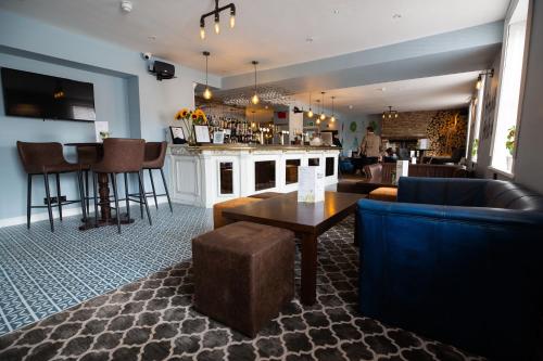 塞奇菲尔德Hardwick Arms Hotel的带沙发和桌椅的酒吧