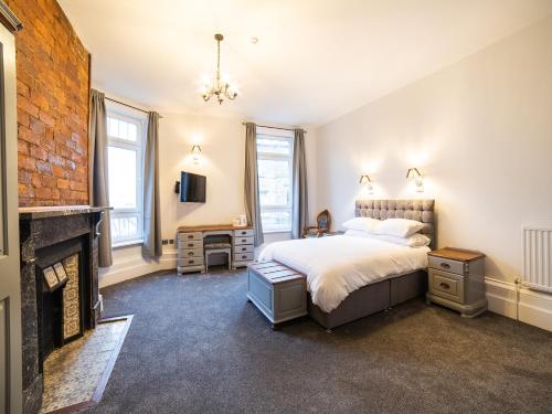 武姆韦尔Churchill's Hotel的一间卧室配有一张床和一个壁炉