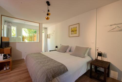 卡普费雷Le Lodge du Cap Ferret的卧室设有一张白色大床和一扇窗户。