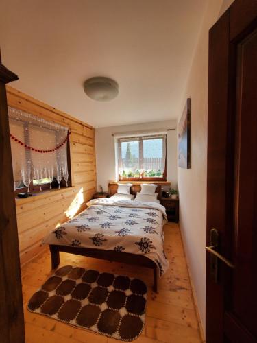 考斯赛力克Apartament z widokiem na Giewont的一间卧室配有一张带 ⁇ 格地毯的床