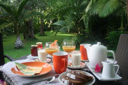 PaïtaCHAMBRES LEZARD Home的餐桌,带食物盘和橙汁杯