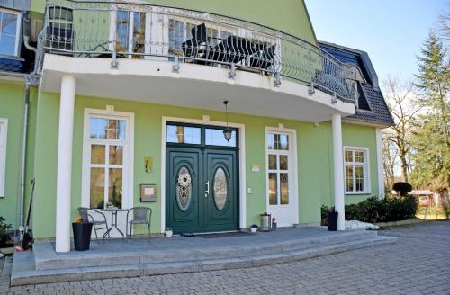 ColdevitzGutshaus_Appartements mit Kamin_ S的绿色建筑,设有绿门和阳台