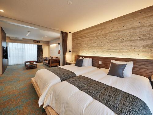 读谷村Yomitan Condhotel ND的一间酒店客房,房间内设有两张床