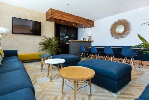 科尼尔-德拉弗龙特拉TAKE SURF Hostel Conil的一间带蓝色沙发的客厅和一间酒吧