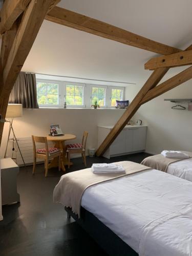 ContheyRelais du Simplon的一间设有两张床和一张桌子及椅子的房间