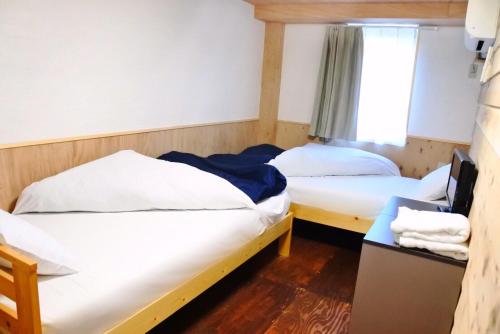 札幌沙伯洛基旅馆的带窗户的客房内的两张床
