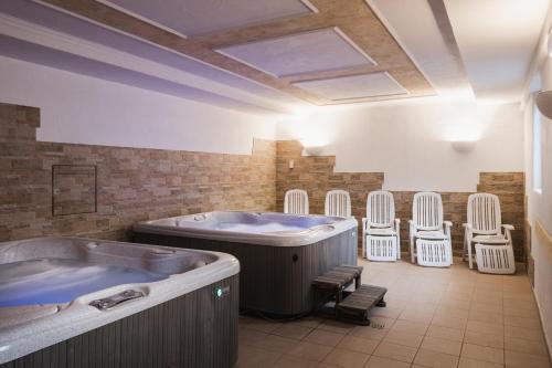 阿拉巴Apparthotel Sellaronda的一间带热水浴缸和椅子的大浴室