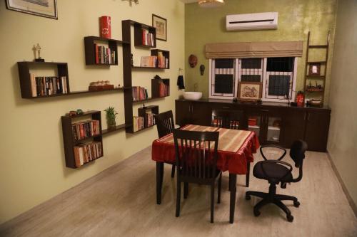 钦奈The Lord's Prayer的用餐室配有桌椅和书架