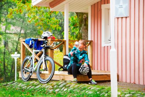 哥德堡Lisebergsbyns Stugor的坐在自行车旁门廊上的一个小女孩