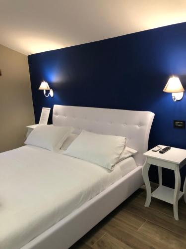 罗马多莫斯蒂贝里纳酒店的卧室配有白色床和蓝色墙壁