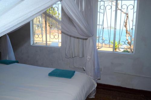 SengaKuwona Cottage的一间卧室设有一张床和两个海景窗户。