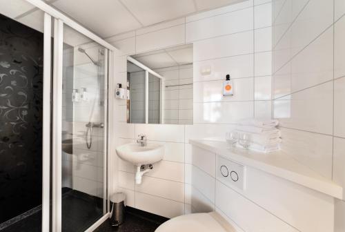 康斯博大康斯博品质酒店的白色的浴室设有卫生间和水槽。
