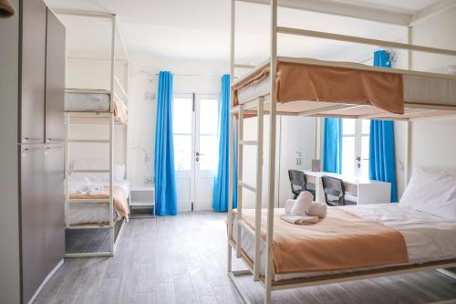 斯利马AM Hostel的一间卧室设有两张双层床和蓝色窗帘