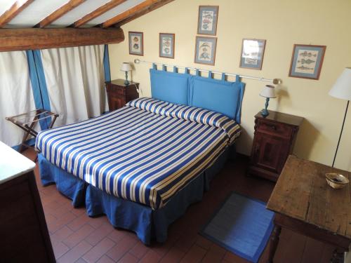 米利亚里诺米利亚里诺农场酒店的一间卧室配有一张蓝色的床和条纹床罩