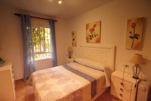 奇克拉纳－德拉弗龙特拉Apartamento Jardín del golf 2的一间卧室设有一张床和一个窗口