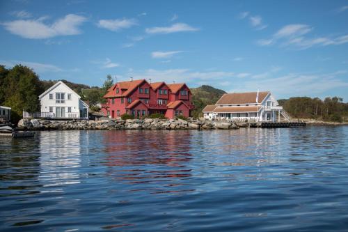 ØsthusvikSjøberg Ferie og Hotell的水体岸边的一群房子