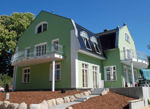 ColdevitzGutshaus_Appartements mit Kamin_ S的绿色房子的顶部设有两个阳台
