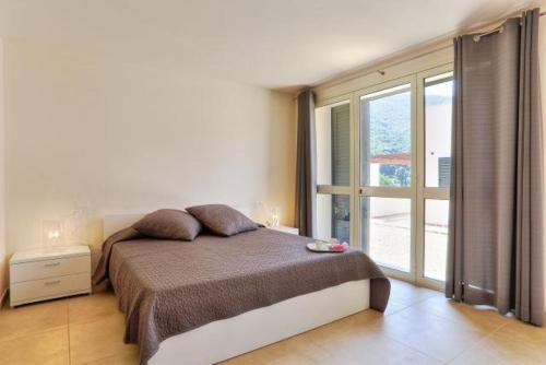 里奥内莱尔巴Villetta Natura Casa B的一间卧室设有一张大床和一个大窗户