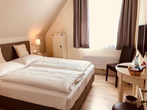 Schwentinental克劳斯多尔福霍夫酒店的卧室配有白色的床、书桌和窗户。