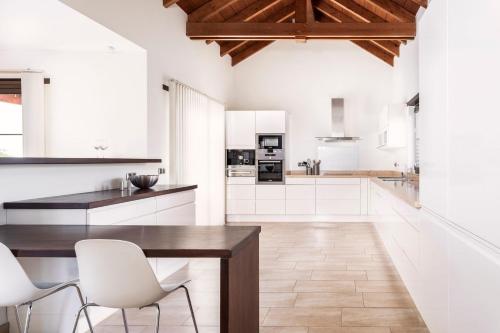 拉哈雷斯Villa Annunaki的厨房配有木桌和白色椅子