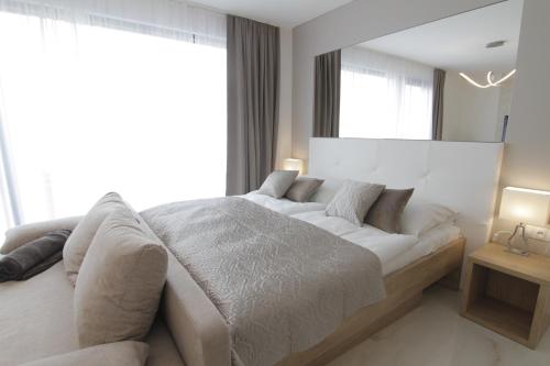 米库洛夫Apartmány ROSE Mikulov的卧室设有白色的床和大窗户