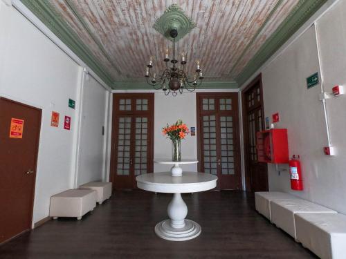 圣地亚哥Pariwana Hostel Santiago的一间房间,桌子上放着花瓶