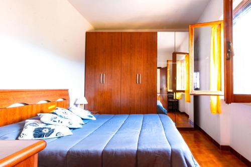 马尔恰纳Villetta Ivana的一间卧室配有一张蓝色的床和木制橱柜。