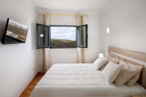 阿里亚Apartamento Ye的卧室设有一张白色大床和两个窗户。