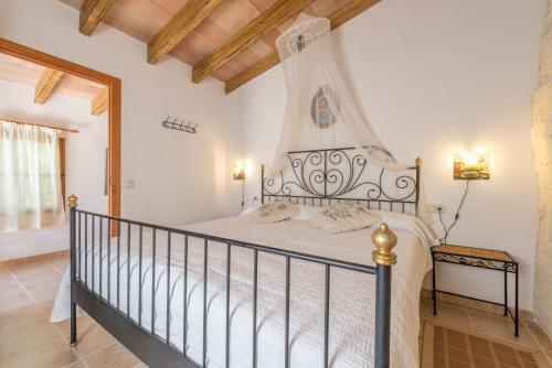 Sant JoanSa Caseta den Tronca的卧室配有白色床和锻铁床头板