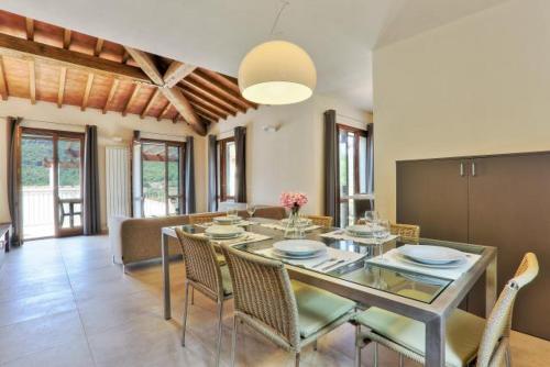 里奥内莱尔巴Villetta Natura Casa A的一间设有玻璃桌和椅子的用餐室